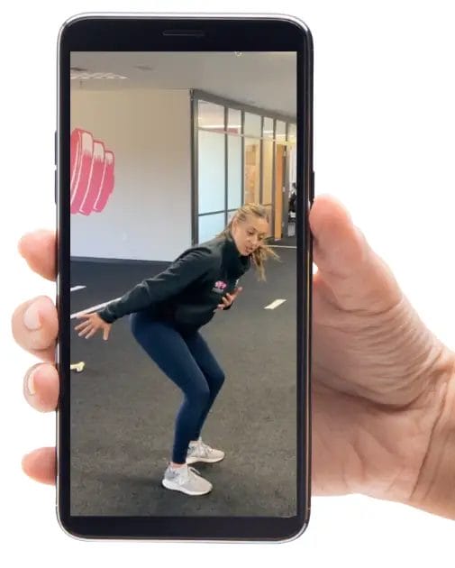 Athlete performing a workout while following a Relentless Athletics training session on a mobile phone