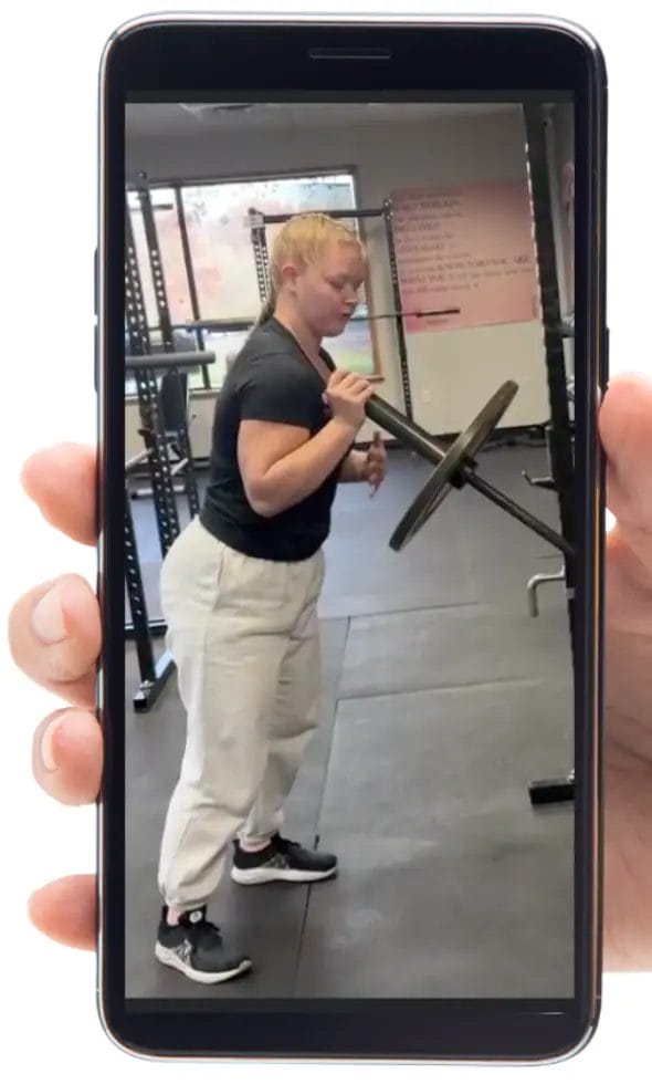 Personal training session at Relentless Athletics gym with coach guiding an exercise